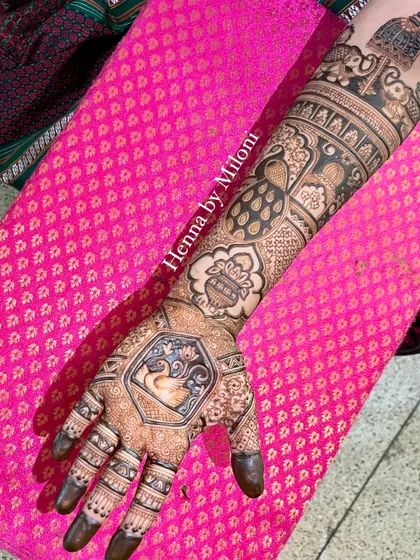 A classic bridal arm design featuring a central swan motif, a kalash, and peacocks. Choosing the right artist ensures your mehendi is a work of art.