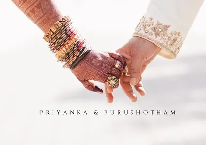 A symbolic photo of the couple holding hands, showcasing the bride's bangles and the start of their journey as 'Priyanka & Purushotham'.