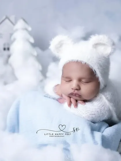 A winter wonderland for this little bear. The all-white theme with fluffy clouds and miniature houses creates a magical, snowy village scene.
