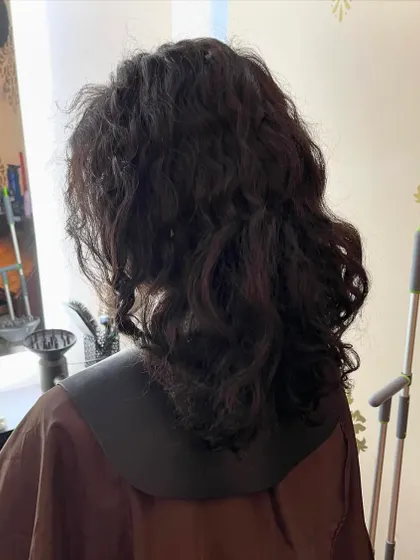 The 'before' shot for Aditi's curly mullet, showing her hair ready for a new, modern shape.