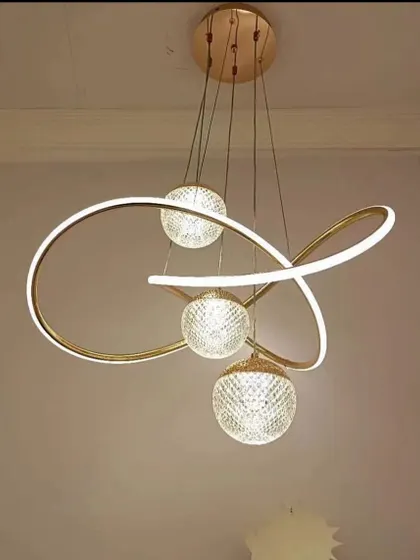 An abstract pendant light with a swirling LED ribbon and crystal-cut globes. This fixture is a piece of art, perfect for a modern home that values unique design.
