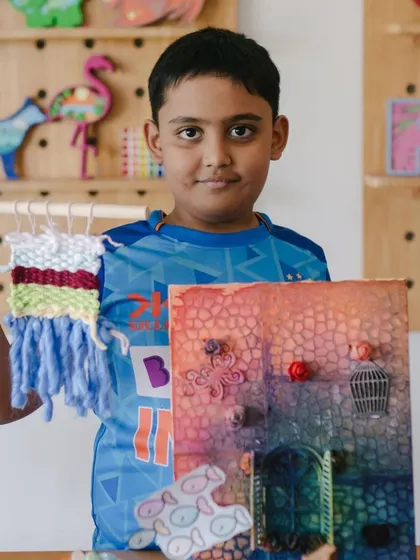This young man is showing off his woven tapestry and his intricate coral reef diorama, two of the many projects we worked on during camp.