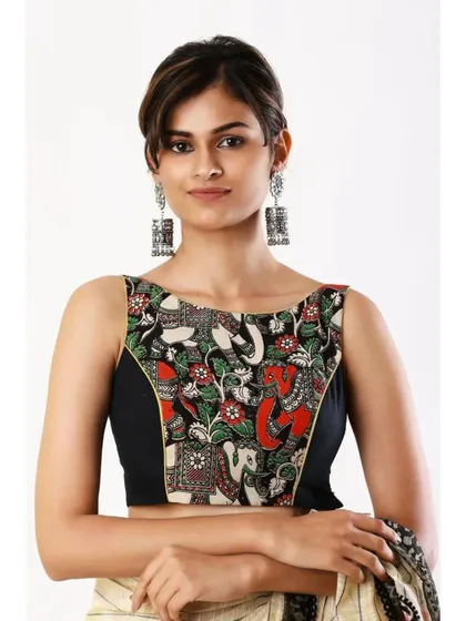A boat-neck Kalamkari blouse featuring elephant motifs is paired with oxidized silver jhumkas for a rustic and artistic look.
