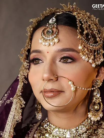 This stunning bridal look, created by one of our students, features dramatic winged eyeliner and a traditional nath. It's a testament to the detailed artistry they learn to master.