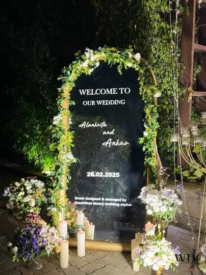 A personalized welcome for the couple. This elegant mirror signage, framed with fresh white flowers and greenery, greeted guests at the entrance of the reception.