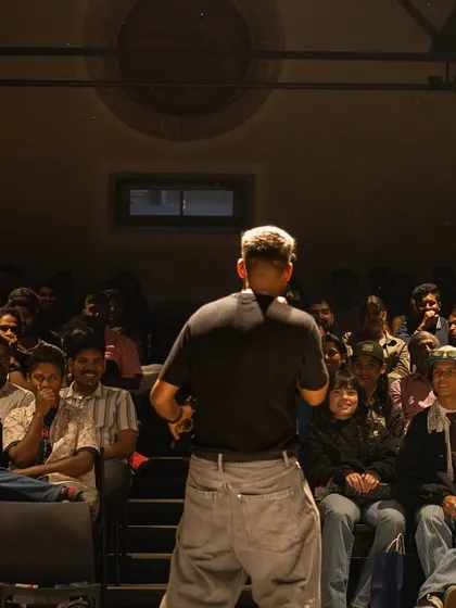I face the seated Monsoon Jam audience at Sabha Bengaluru, with people gathered across the room around the floor.