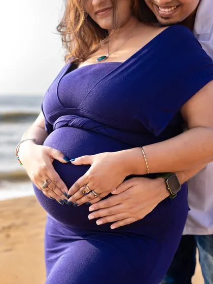 Both partners' hands creating a heart on the baby bump is a beautiful symbol of their shared love and excitement for their new arrival.