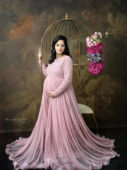A graceful portrait in a dusty pink gown. Posed next to the golden birdcage against a floral backdrop, this image is the epitome of romantic elegance.