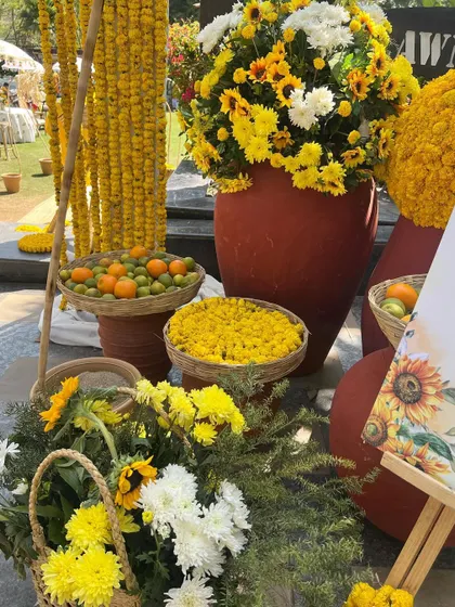 Fun and quirky elements for a haldi, including baskets of fresh oranges and lemons alongside traditional marigolds and sunflowers.