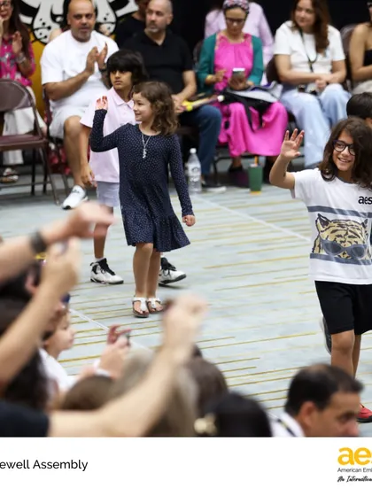 Elementary students wave to their families and friends during the Farewell Assembly. It's a heartwarming celebration of their growth, friendships, and the supportive community they are a part of.