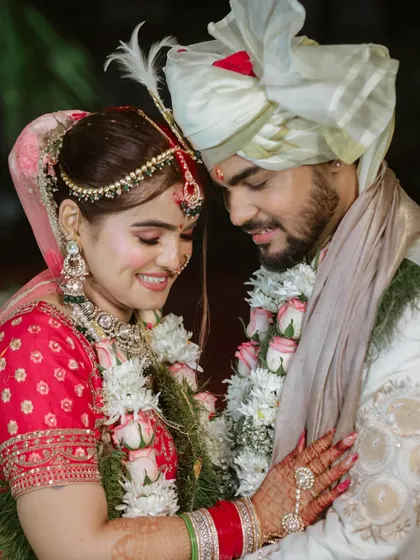 A beautiful close-up of the couple, capturing their serene smiles and the intricate details of their wedding attire.