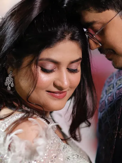 A tender moment. The soft, shimmery eye makeup adds a touch of romance and glamour to her Sangeet look.