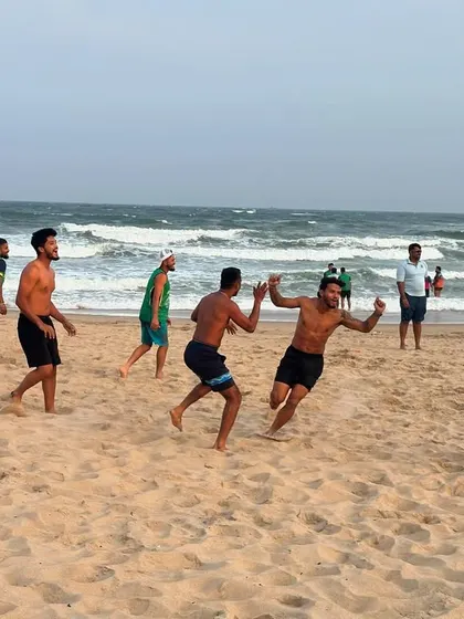 The players fully engaged in a competitive game on the sand. This is where team spirit is forged.