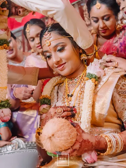 A bride's serene expression during a wedding ritual, holding a sacred coconut. This shot beautifully captures a moment of devotion and tradition.