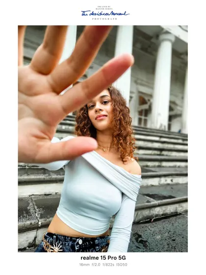 A more interactive and dynamic portrait from the same session. The hand reaching towards the camera adds a layer of engagement and breaks the fourth wall, making the viewer feel present.