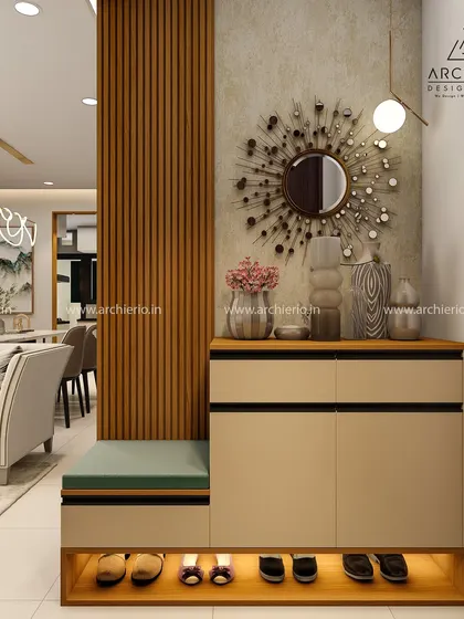 A functional and stylish foyer with a shoe cabinet that includes a seating bench, set against a wall with a modern sunburst mirror and fluted paneling.