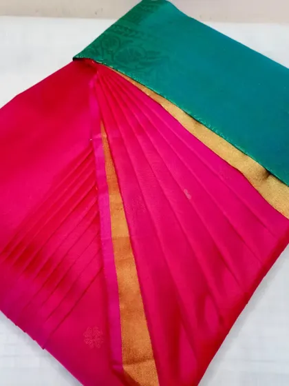 A simple and elegant pink saree with a green border. The pleats are perfect, making it a great choice for any occasion.