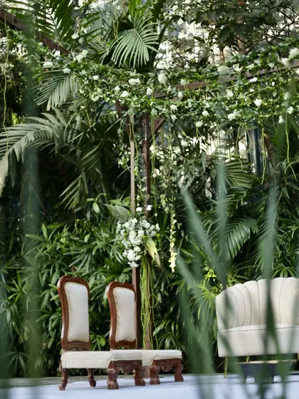 A closer look at the seating for a green and white themed ceremony, showing the blend of modern chairs with traditional elements.