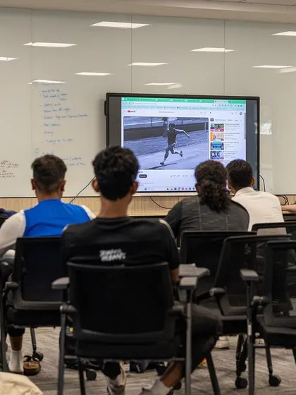 Participants watch a video analysis of athletic movement, a key part of learning to break down and coach complex skills.