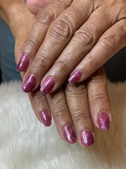 A recap photo showing a sparkling pink glitter polish on natural nails.