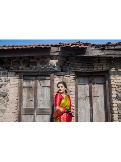 A wide shot of the bride against a rustic building, emphasizing the unique and beautiful setting for her portraits.