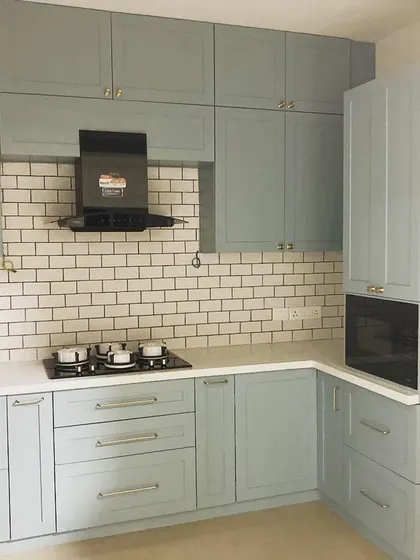 Another look at this classic English-style kitchen. The soft blue-grey cabinets and white subway tiles create a timeless and calming atmosphere.