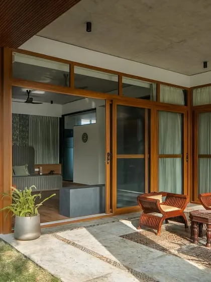 The master bedroom's exterior, showcasing the laterite stone cladding and its connection to the private garden.