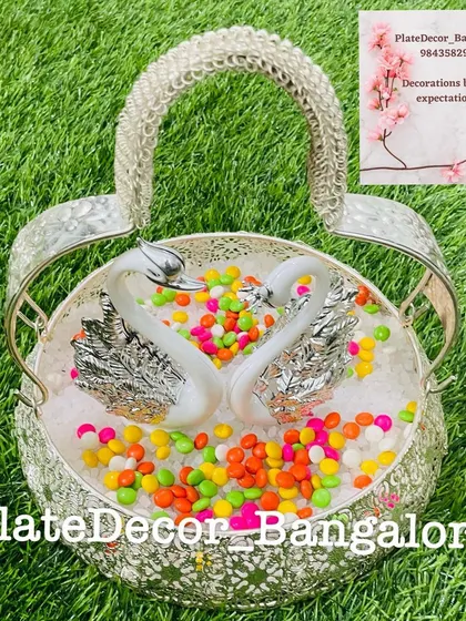 A playful arrangement in a silver swan basket, filled with colorful gem-like candies. This is a fun option for children's events or puberty ceremonies.