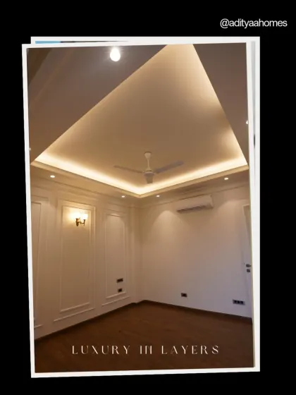 Luxury is layered. This room showcases it perfectly, with its high-end wooden flooring, detailed wall panels, and a beautifully designed false ceiling with integrated lighting.