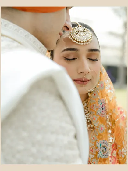 A moment of stillness and peace. The groom's gentle kiss on his bride's forehead is a powerful symbol of love and protection.