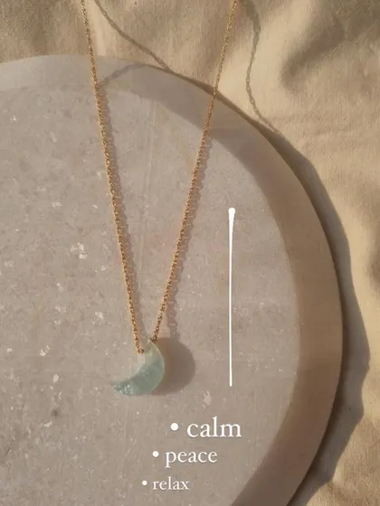The Aquamarine Luna Pendant, a beautiful crescent moon carved from a stone that brings calm, peace, and relaxation.