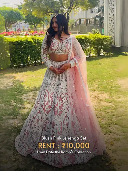 A blush pink lehenga set with intricate white lacework. A classic and elegant choice.