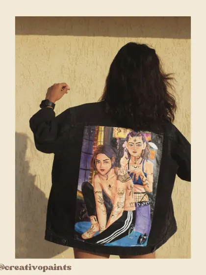 A model wearing the custom-painted jacket, demonstrating how the piece looks in a real-world setting. The detailed artwork on the back is designed to be a conversation starter.