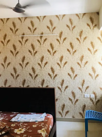 A repeating wheat stalk pattern on a textured background, adding a rustic yet modern touch to this bedroom wall.