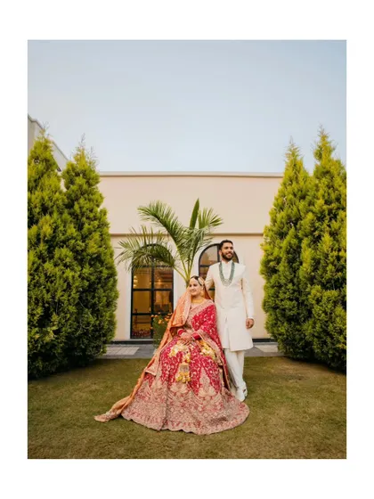 A grand, full-length portrait of the couple on their wedding day. Their regal attire and the elegant setting create a stunning and memorable image.