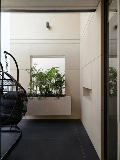 A quiet, contemplative corner within Villa Aish. This small balcony with its built-in planter and hanging chair is one of the many intimate "moments" we design into our homes, providing personal retreats within the larger family residence.
