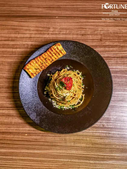 An overhead shot of our classic spaghetti, elegantly plated on a dark dish to make the colors pop.