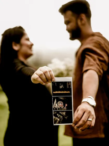 A creative shot where the sonogram pictures are in the foreground, with the out-of-focus couple in the background. It beautifully symbolizes that their focus is on the baby to come.