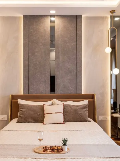 A symmetrical headboard design featuring textured grey panels flanked by mirrors and elegant pendant lights. This creates a sense of balance and luxury in the master suite.