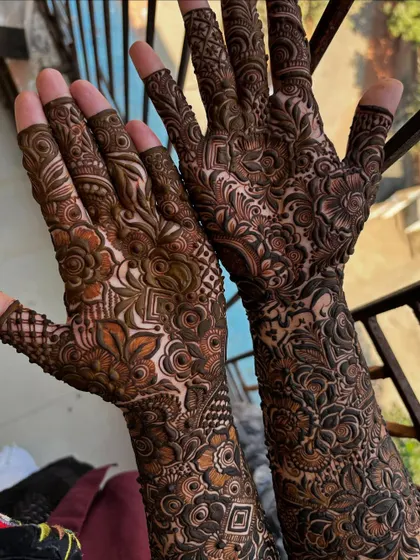 A stunning full-arm design captured in natural daylight, which highlights the different tones in the henna paste and the complexity of the patterns.