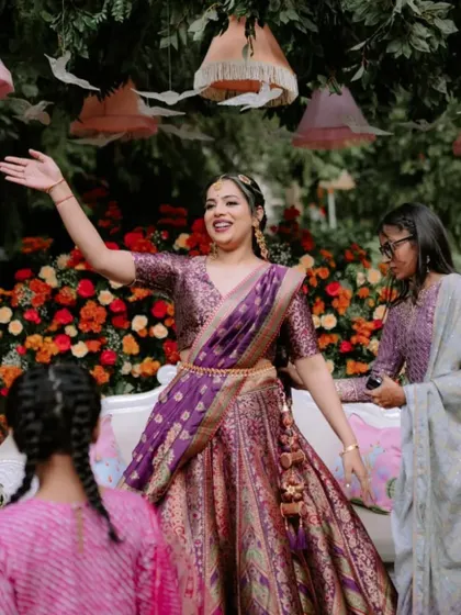 Another joyful shot of the bride at her Mehendi ceremony, surrounded by family and beautiful floral decor.