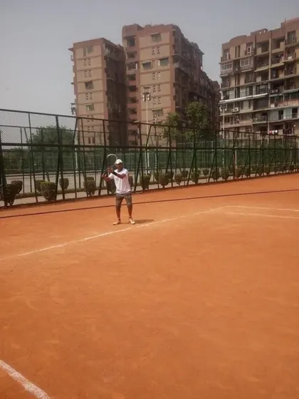 A player practices his serve on the clay court during a morning session. The serve is one of the most important shots in tennis, and we dedicate significant time to perfecting it.