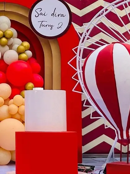 More details from the carnival setup, showcasing the vibrant red and white color scheme and the hot air balloon prop.