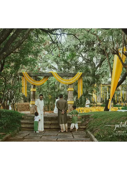 An elegant and minimalist setup at Shankaraa Foundation, with stone pillars adorned with simple floral garlands.