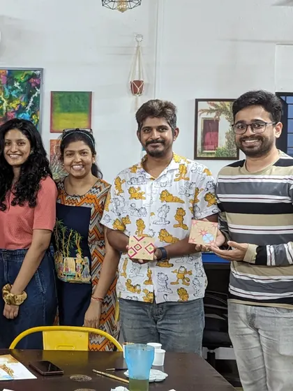 A group of friends showing off their finished Moroccan-inspired art pieces.