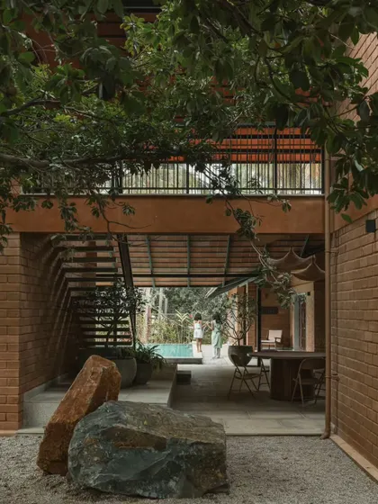 We preserved the natural landscape by incorporating existing trees and large boulders into the courtyard design. This view from the gravel court looks through the open dining area towards the pool.