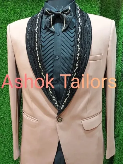 A unique party blazer in a peach color with a heavily embellished black shawl lapel.