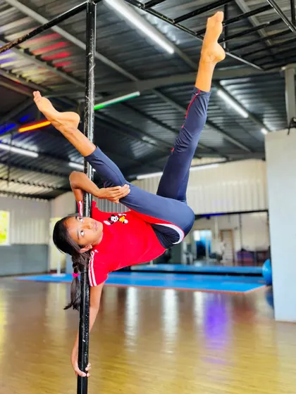 A stunning display of strength and precision. This young girl is redefining what it means to be powerful with this impressive inverted split on the pole.