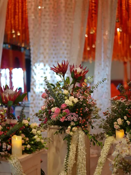 A beautiful floral arrangement at the entrance of the wedding ceremony. We used a mix of exotic proteas and classic roses to create texture and visual interest.
