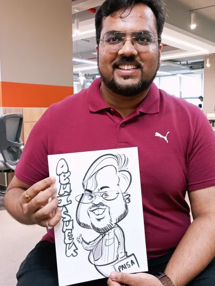 An employee from a corporate event holding his personalized caricature. This is a unique way for companies to show appreciation for their team members.